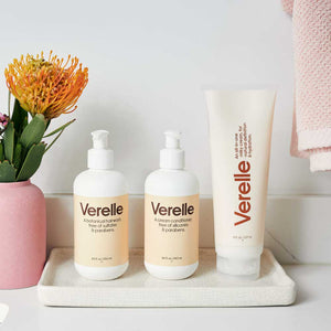 Verelle curly set with shampoo conditioner and curly all in one milky cream on bathroom counter next to flower vase