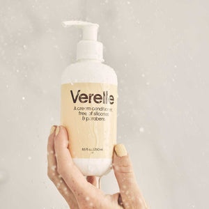 hand holding verelle cream conditioner in shower
