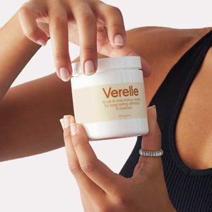 model hands are holding verelle coily all in one styling cream